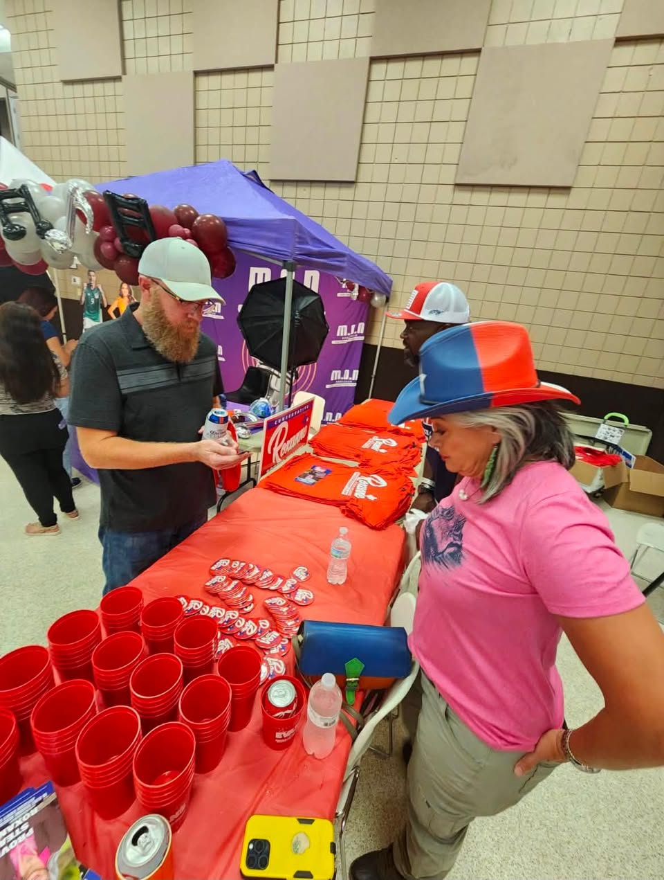 Visitors and volunteers around the PAC table at Fiestas 58
